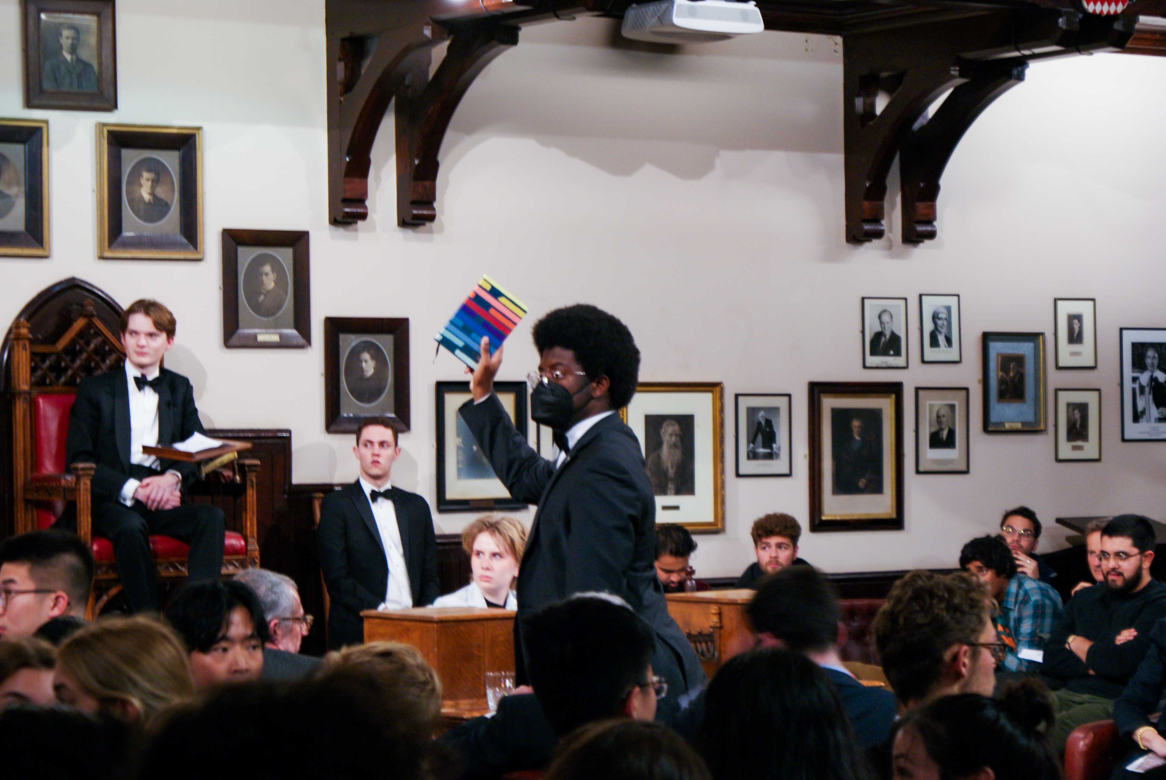 Student speaker, Cambridge Union, holding notebook